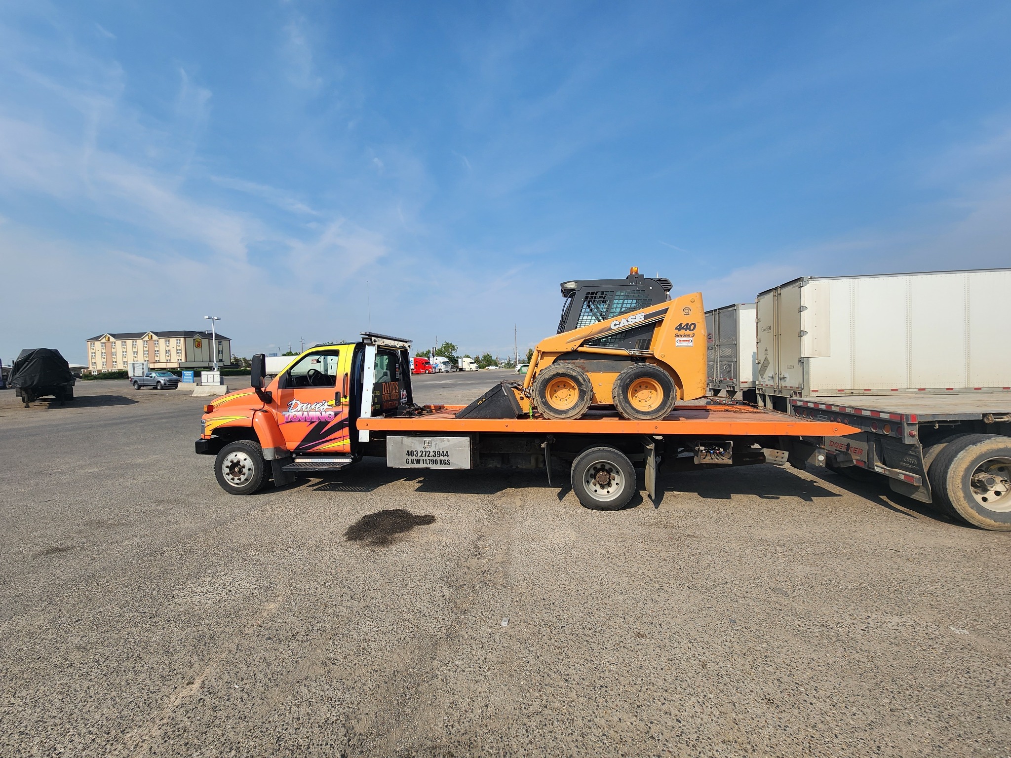 Equipment transport on flatbed tow truck